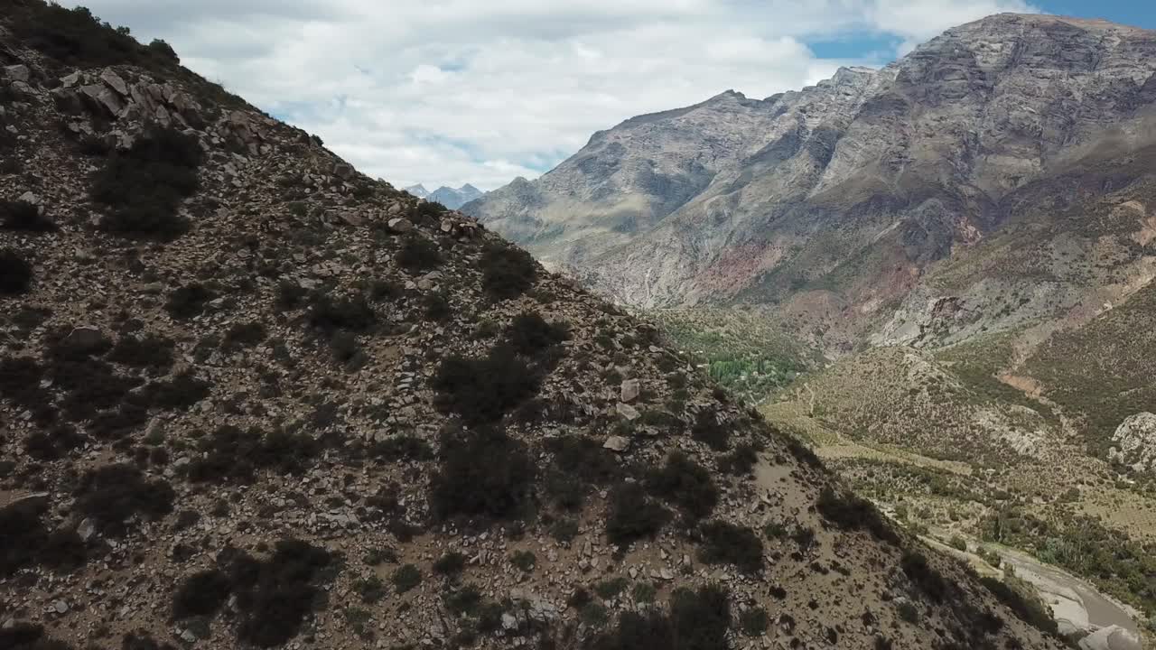 Aerial Revealing View of Picturesque Valley Under Dry Hills and Snow Capped Mountain Peaks, Chile