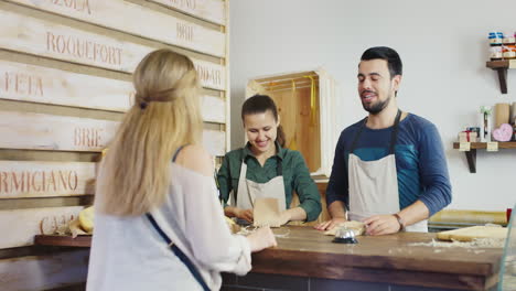 una mujer compra queso en una pequeña tienda familiar concepto de pequeña empresa