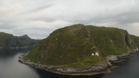 aerial view of road on rugged mountain leading to hendanes lighthouse in the town of maloy, near the island of vagsoy in norway