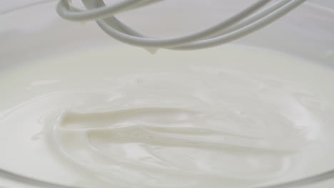 whipping cream being mixed with whisk