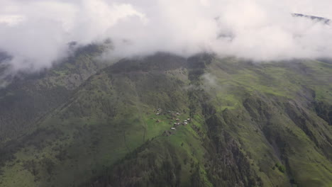 Filmische-Absteigende-Drohne-Schoss-Durch-Die-Wolken-Eines-Kleinen-Dorfes-Auf-Einem-Berggipfel-Im-Dorf-Tusheti-In-Georgia