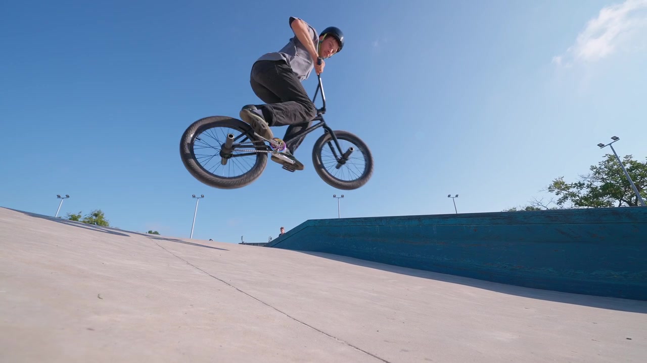 Rider BMX che esegue un trick di salto aereo in uno skate park