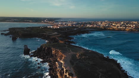 Vista-Aérea-Suave-Del-Acantilado-De-Papôa-En-Una-Soleada-Mañana-Dorada-En-Peniche,-Portugal