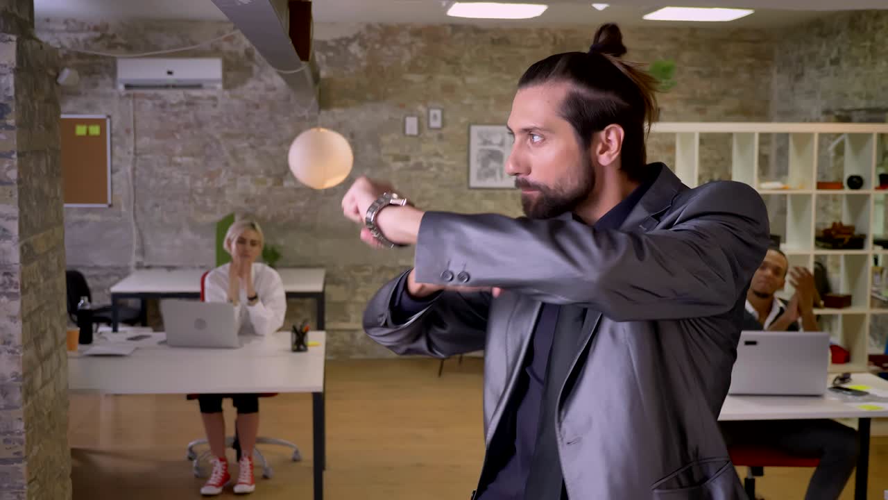 Happy businessman with beard is dancing in office, smiling, colleagues are clapping, work concept, relax concept