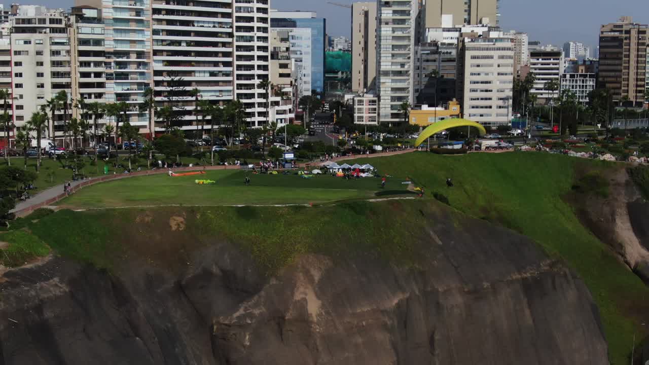 Video 4K seorang paralayang terbang di atas pesisir hijau Samudra Pasifik di distrik Miraflores, Lima, Peru