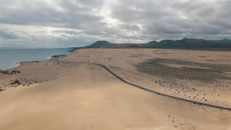 drone flight throw the coast of fuerteventura with mountains in backround and the atlantic ocean