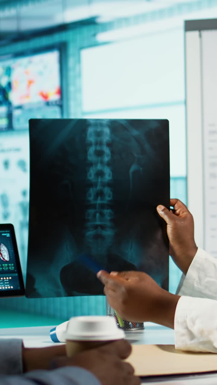 Doctor and Patient Examining Spine X-ray in Medical Office