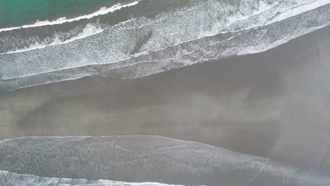 narrow whale tail beach with rainforest in costa rica washed by waves