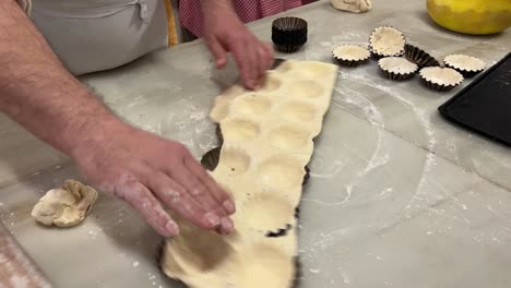 Traditional-baber-prepares-homemade-cupcakes-in-his-bakery,-over-a-marble-table