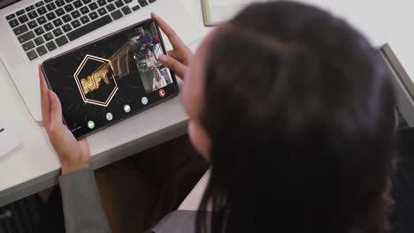 Biracial-businesswoman-using-tablet-for-video-call-with-diverse-business-colleagues