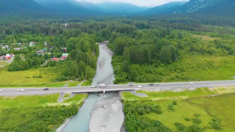 4k cinematic drone video of seward highway alaska route 1 over glacier creek with girdwood, ak in background