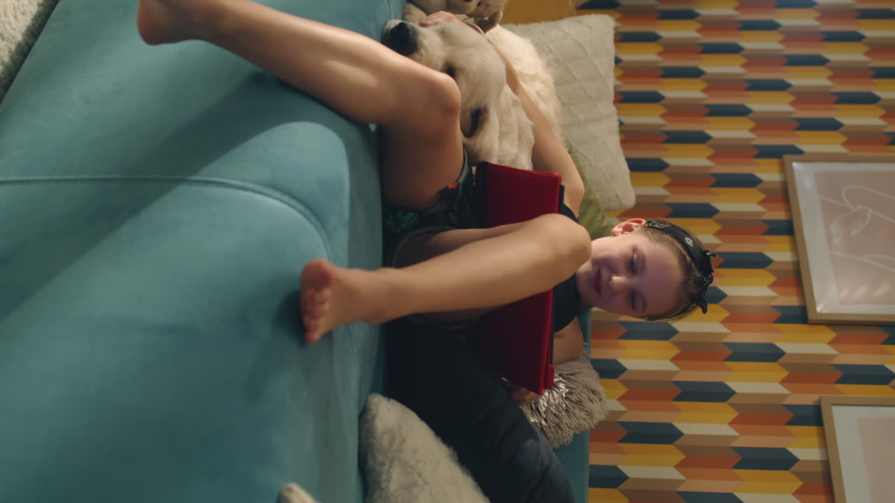 Girl and dog playing on couch