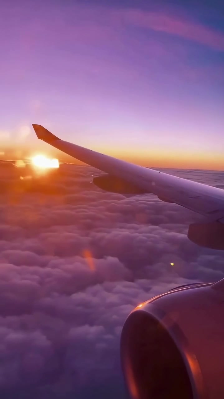 Ala de avión volando sobre las nubes durante el atardecer