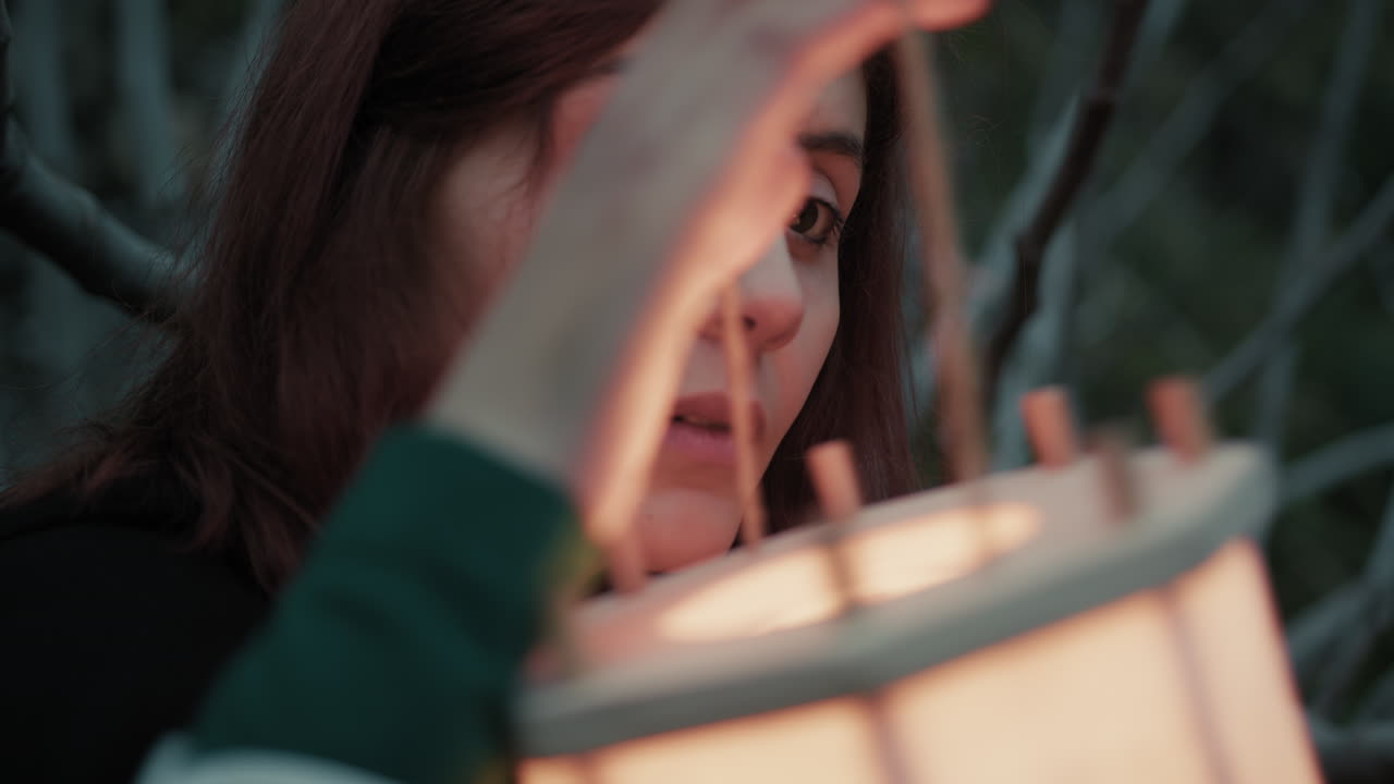 una mujer reflexiona sobre el futuro incierto con una linterna por la noche en un bosque espeluznante.