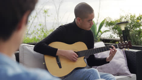 joven caucásico tocando la guitarra en un techo