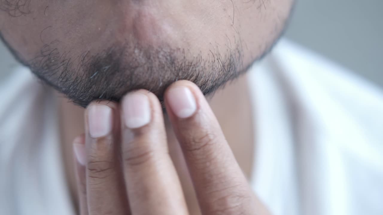 hombre comprobando su barba y cuello