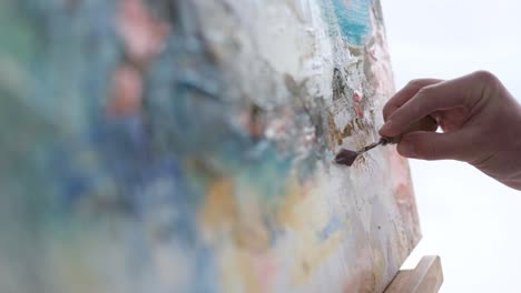 young talented artist working on abstract painting uses paint brush to create picture working in