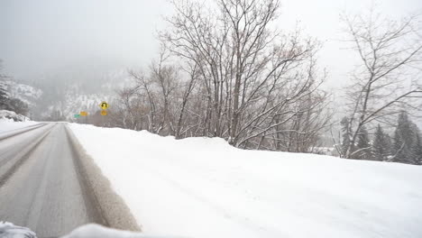 driving on snowy icy road in rural countryside on cold winter season, right seat passenger point of view, slow motion