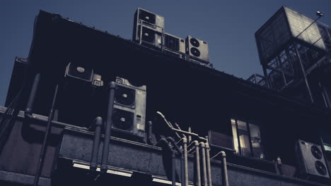 industrial building with air conditioning units and piping at twilight