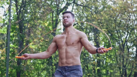 young man jumping rope outdoor. view of active man doing workout with jumping rope at stadium