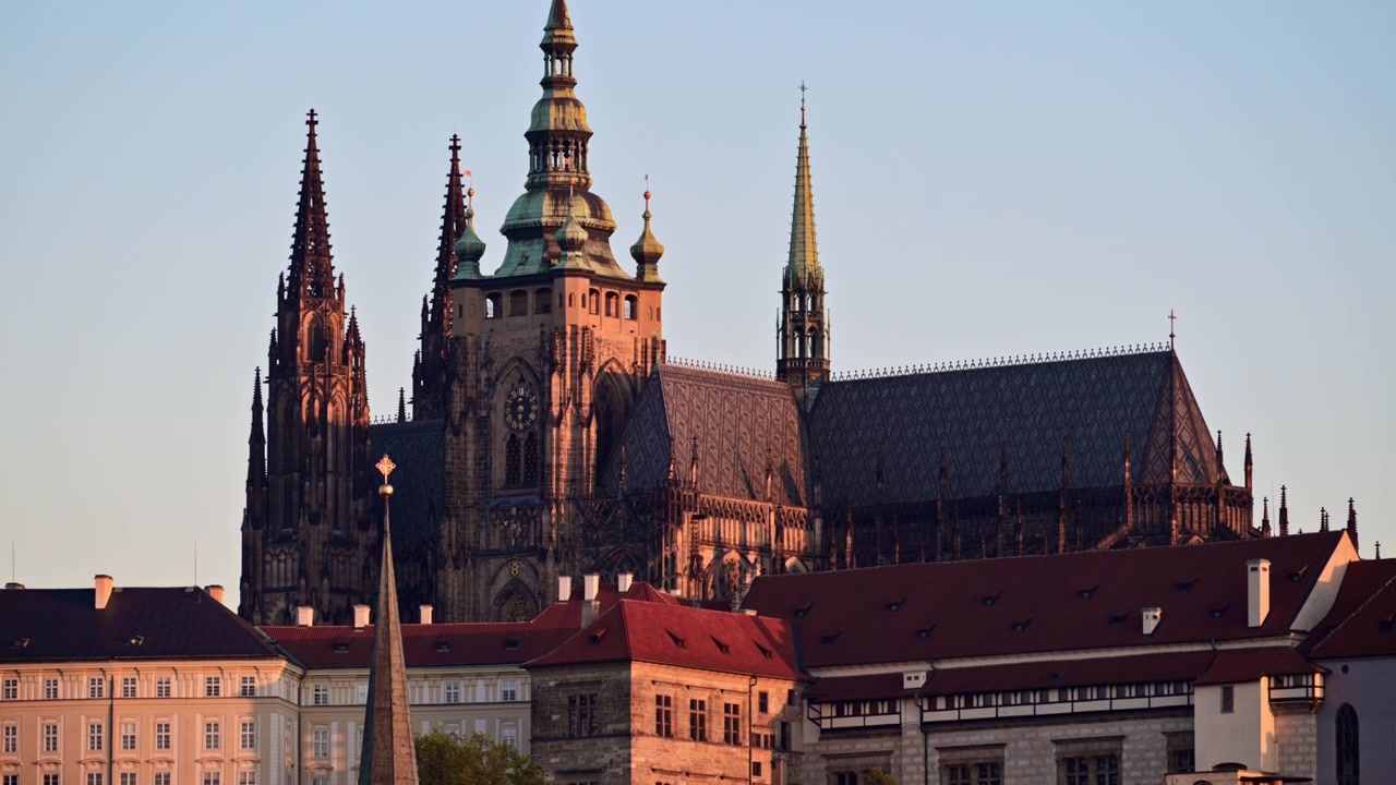 Vista della Cattedrale di San Vito sopra i tetti rossi del Castello di Praga alla calda luce dell'alba, Praga, Repubblica Ceca