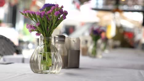 vase of purple flowers on a restaurant table