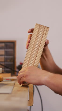 leathersmith installs tool on workbench surface to process leather in workshop closeup. master crafts original accessories from natural leather material