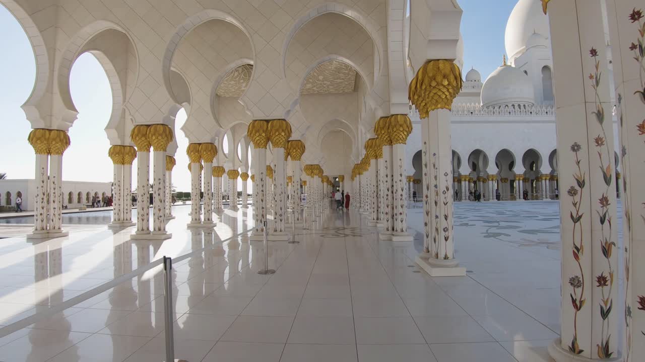 Passeggiata al rallentatore attraverso il corridoio bianco e dorato della Grande Moschea di Abu Dhabi