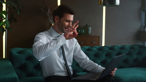 businessman having video chat on laptop with green screen at home office