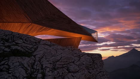 modern wooden architectural structure on a mountain cliff at sunset