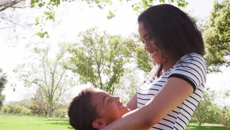 Toma-En-Cámara-Lenta-De-Una-Madre-Abrazando-A-Su-Hijo-En-El-Parque