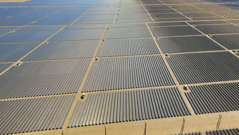 Photovoltaic-solar-power-panel-station-farm,-pull-back-aerial,-desert-landscape