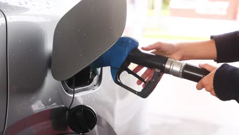 person refueling car at a gas station