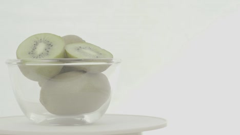 kiwis verdes frescos y maduros en cuenco giratorio, no clasificados
