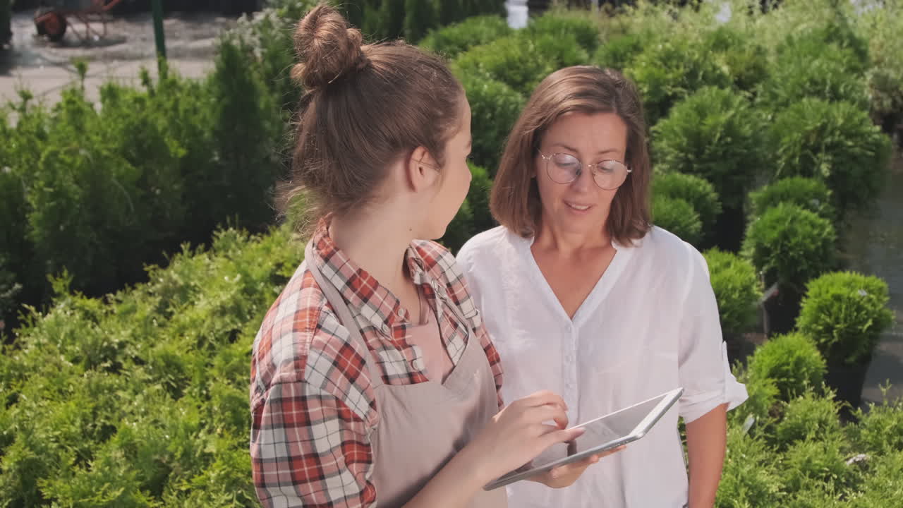 Two women at a garden center looking at a tablet