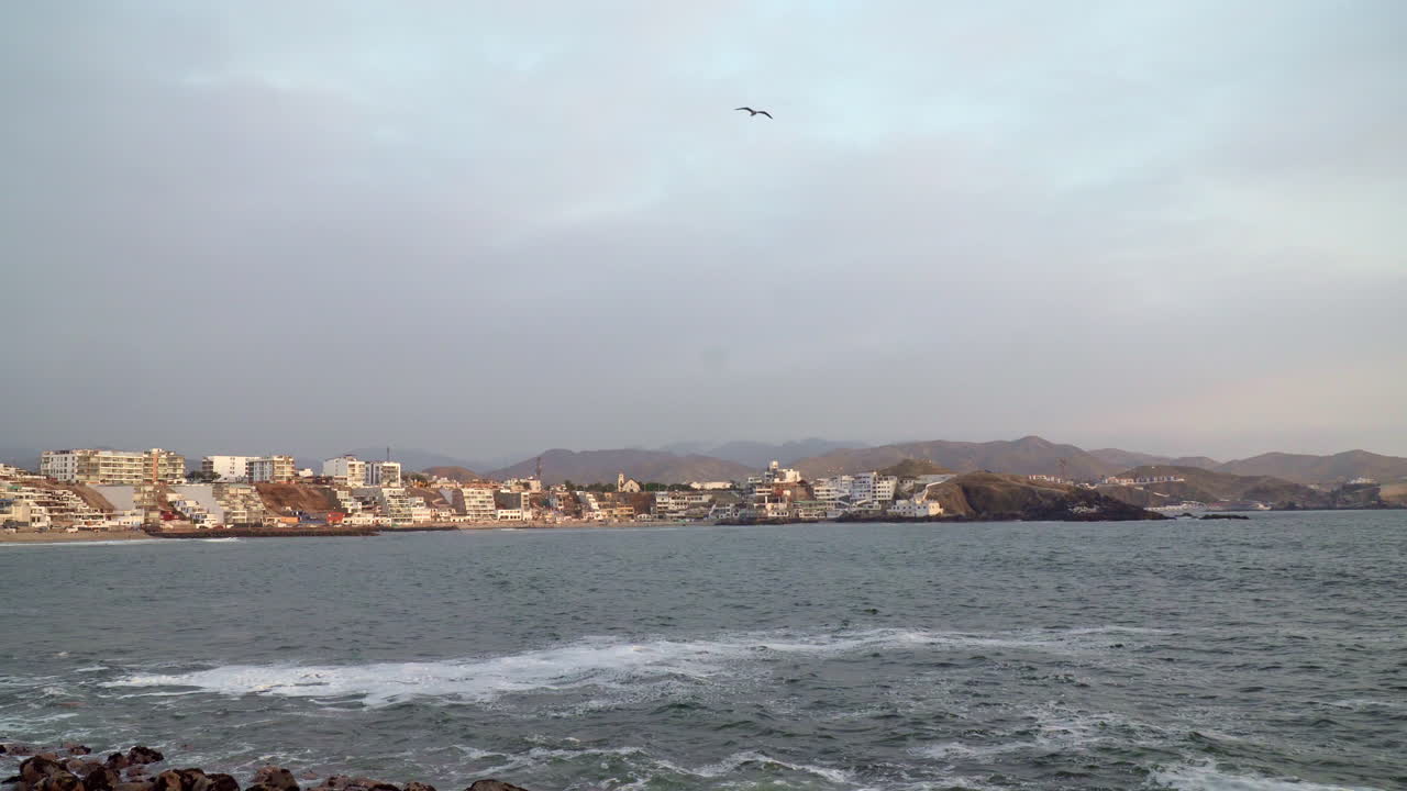 todavía toma de aguas tranquilas por una playa rocosa en san bartolo, lima, perú
