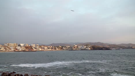 still shot of calm waters by a rocky beach in san bartolo, lima, peru