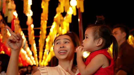 happy asian family standing over light from thai lanna lanterns background at night in yi peng festival.