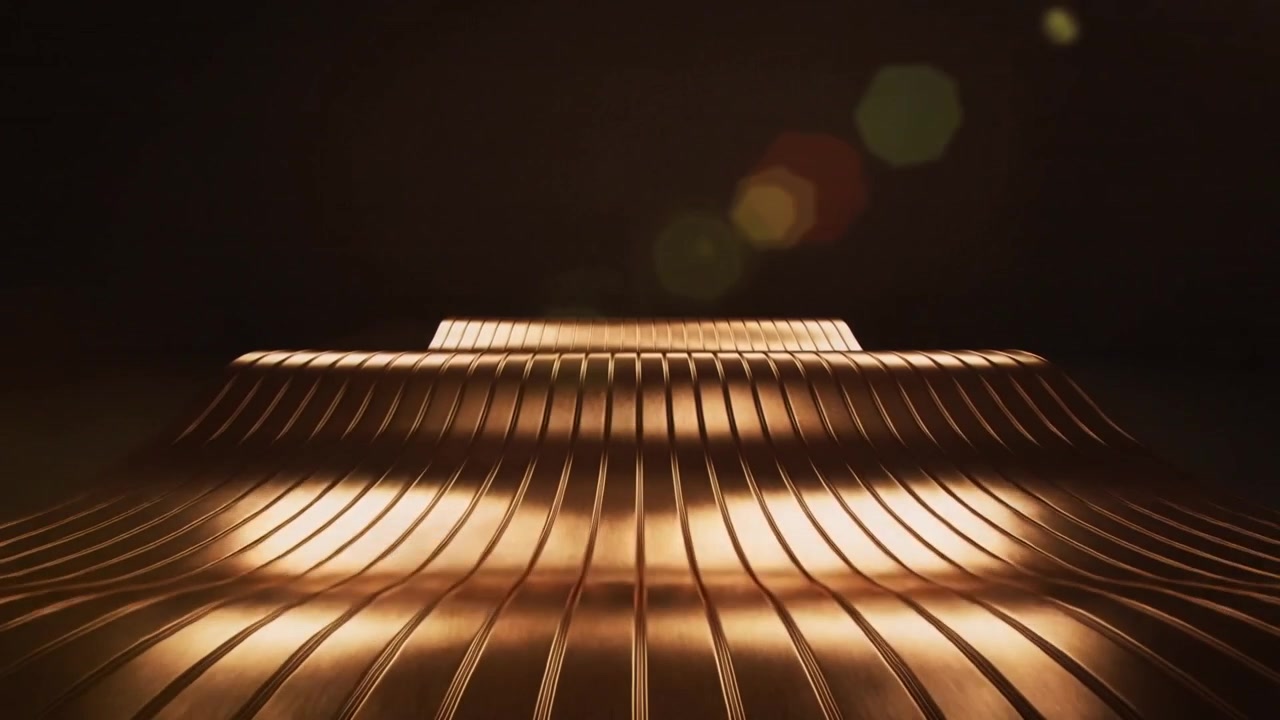 Moving lights sweeping across gold ribbed metal at studio creating glints showing stepped plateau