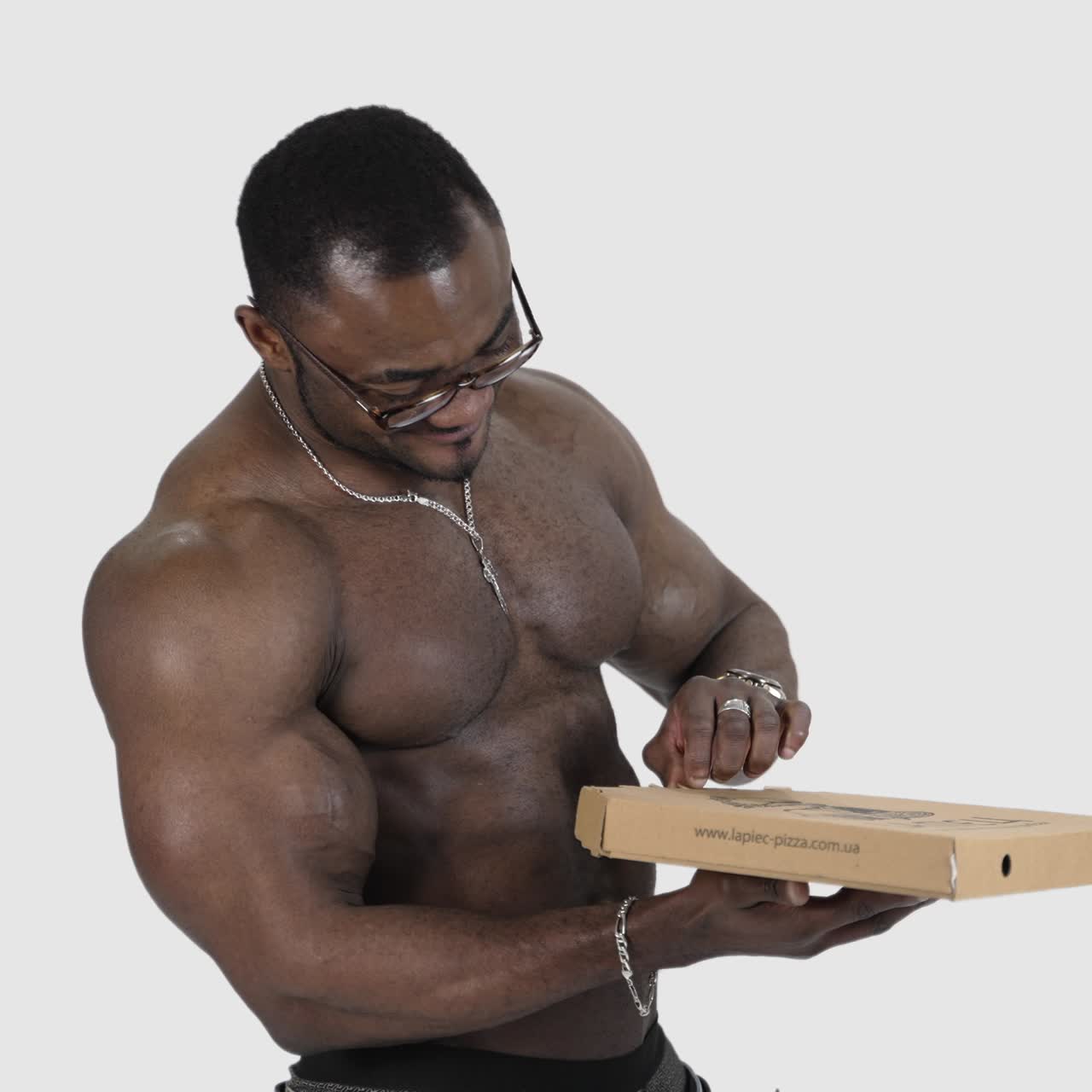 African man with pizza box. Fit man with pizza standing isolated over grey background in studio