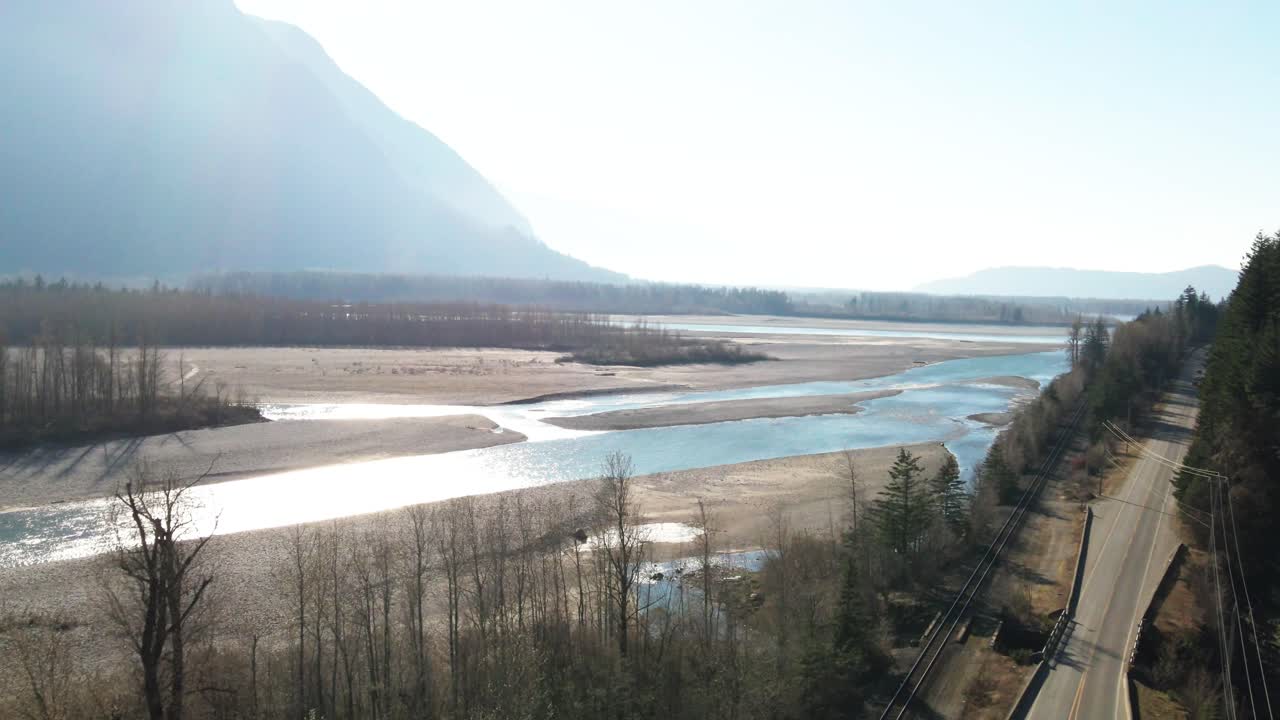 캐나다 브리티시 컬럼비아의 로우어드 7번 고속도로 옆에 있는 프레이저강의 영화적 장면, 가을에는 안개가 자욱한 산들과 도로를 달리는 자동차들이 있는 밝은 장면