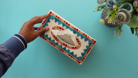 manos sosteniendo una caja de pañuelos decorativos