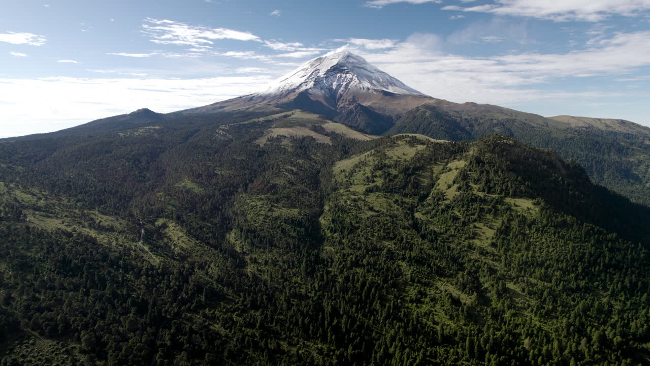 disparo de drones hacia atrás con vista panorámica del pico nevado del volcán popocatepetl en la ciudad de méxico