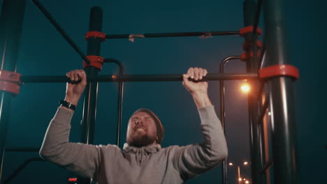 man doing pull-ups at night