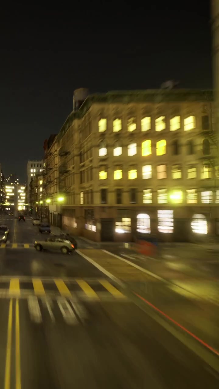 Strade cittadine di notte con auto in movimento e edifici illuminati