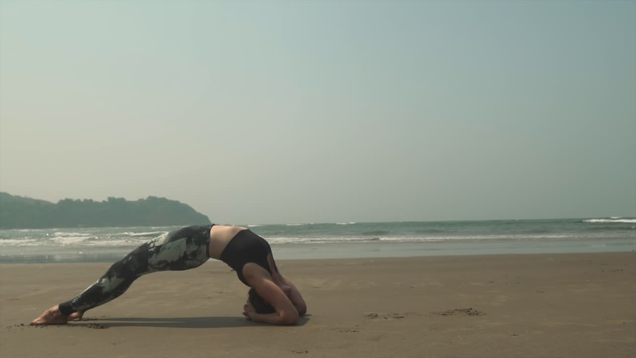 yoga al aire libre puente posición asana mujer ejercicio, tiro estático con fondo de olas de playa