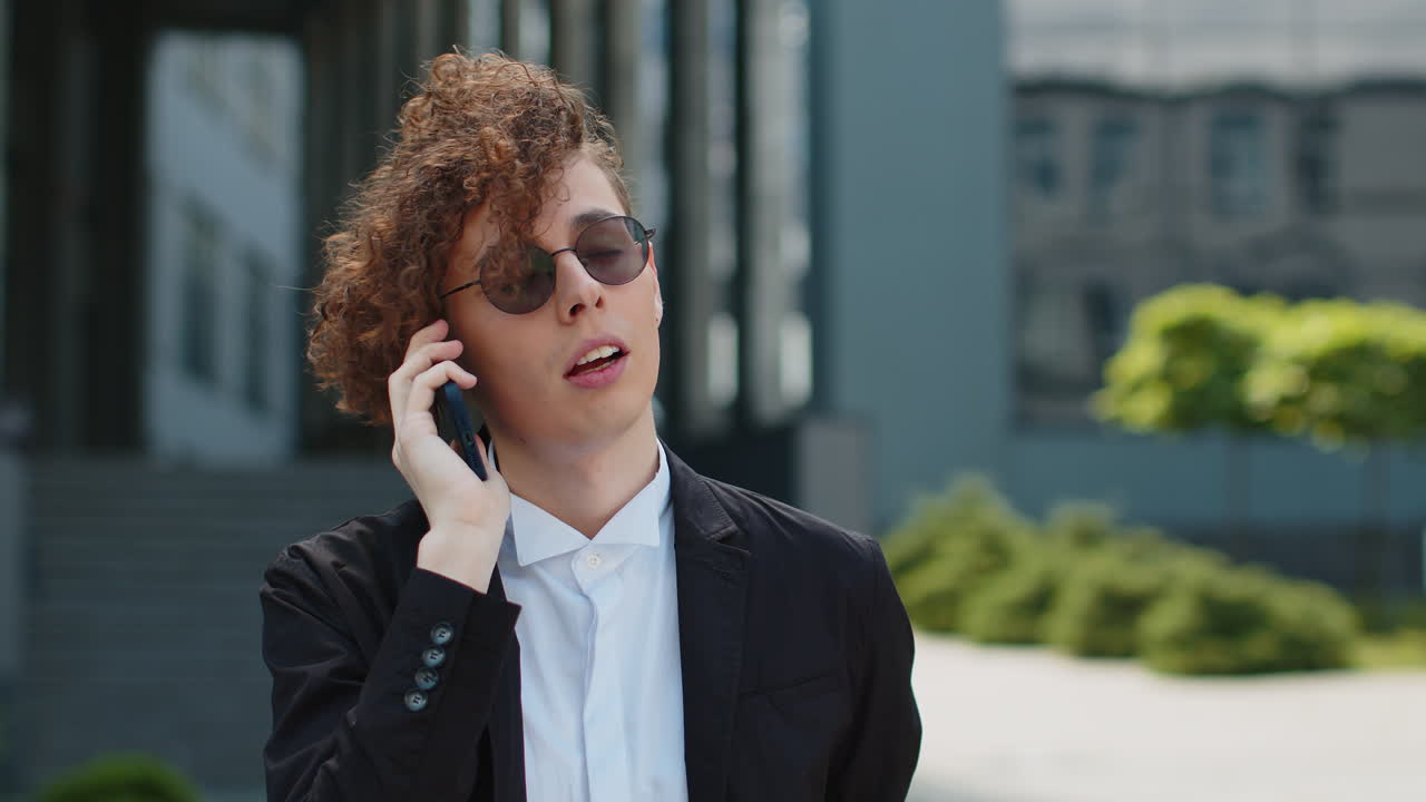 Stressed irritated angry entrepreneur businessman answer call talk phone arguing in city near office