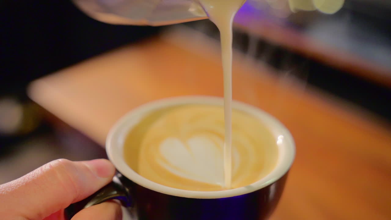 Barista Pouring Milk into Latte Art Coffee
