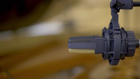 racking focus of two condenser microphones positioned over the strings of an open concert grand piano in a recording studio