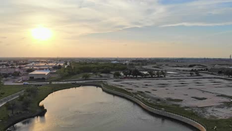 Bei-Sonnenuntergang-Fährt-Man-Von-Einem-Großen-Teich-Weg-Und-Zeigt-Dann-Den-Brunnen,-Der-Den-Teich-Speist,-Zusammen-Mit-Zwei-Anderen-Auf-Der-Rechten-Seite